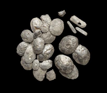 Omsmeltet sølv. De flade smeltekager afløste de lange smalle sølvbarrer, der er typiske for vikingetiden. De mindste barrer vejer knap 20 gram. Der er ingen klar standardvægt; dog er der et tydeligt spring fra omkring 100 gram til de største barrer på godt 200 gram. Omsmeltet sølv.